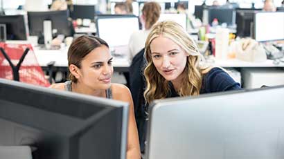 Two students working on computers in a computer lab