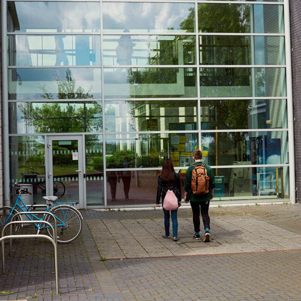 Two students walking towards a University building