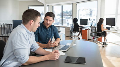 Two business students having a meeting in a busy office