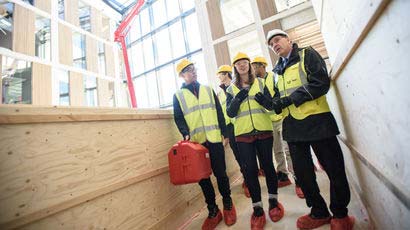 Site Manager leading people around a building.