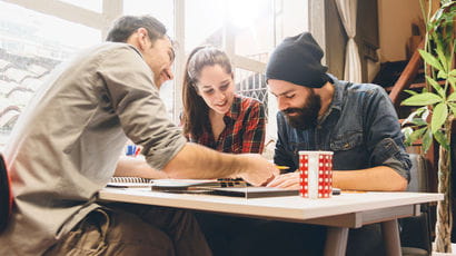 Three people working together in a cafe.