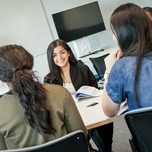 Students sat around a table having a meeting.