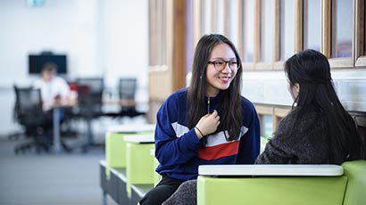 Two international students talking in a study area