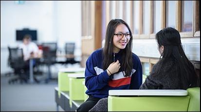 Two international students talking in a study area