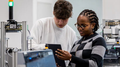 A couple of students using engineering machinery.