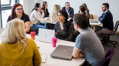 Group of CPD students in discussion in a classroom using laptops