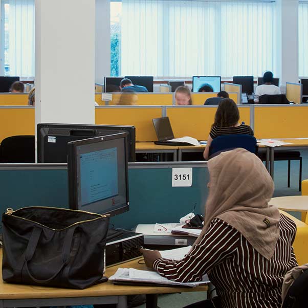 A group of students at computers, in the library.