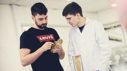 Two healthcare students analysing a specimen in a lab.