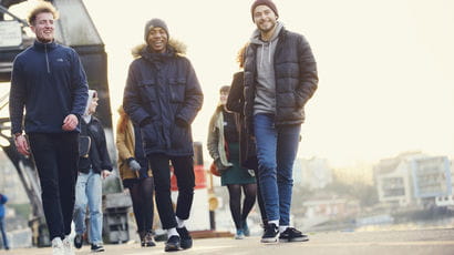 A group of students walking around Bristol harbourside.