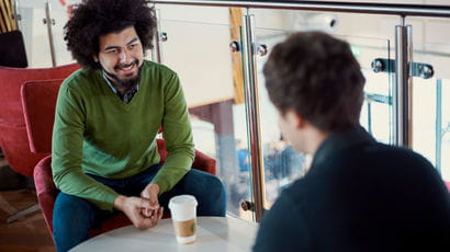 Two students chatting over a coffee.