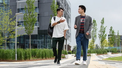 Two international students walking on Frenchay campus, in conversation