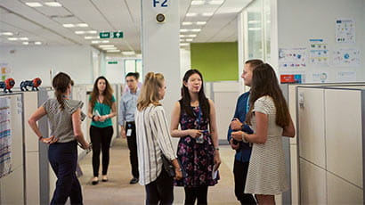 A group of UWE Bristol placements students chatting in an office setting