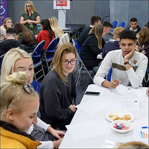 Group of students sat around a table.