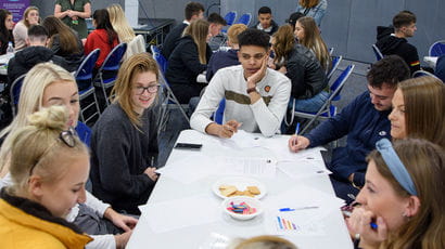 Group of students sat around a table.