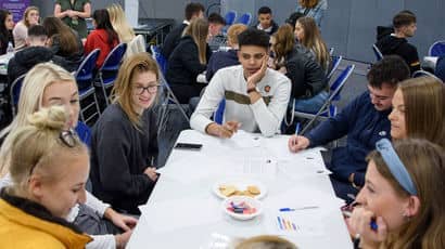 Group of students sat around a table.