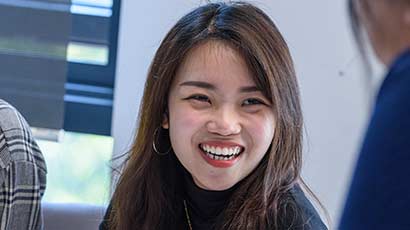 A student smiling, in a classroom.