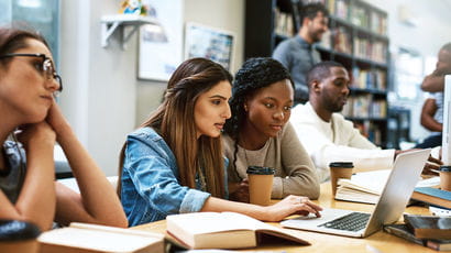 Students working together at a laptop on a media piece