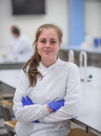 Student Leah smiles in a science lab