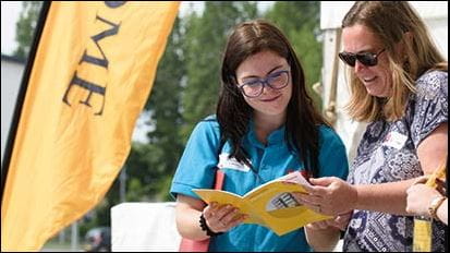 Two people reading an Open Day programme