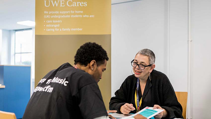 Person getting advice from UWE Cares staff member.