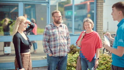 A prospective student, their parents and supporters are welcomed by a UWE Bristol representative.
