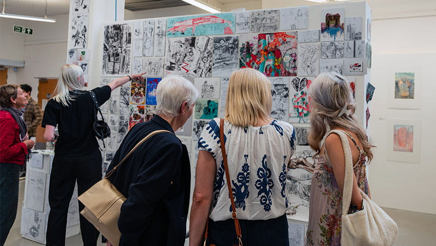 Visitors looking closely at art work on display at Bower Ashton Campus during Open Day.