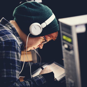 A postgraduate student listening to a podcast whilst working
