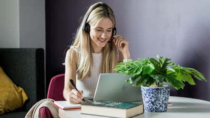 Woman talking into a headset whilst looking at a laptop