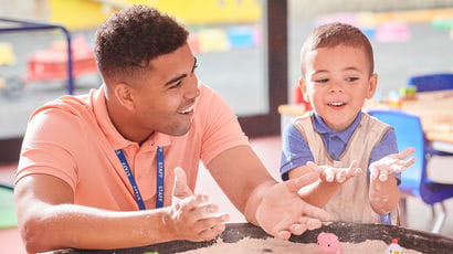 Primary school teacher talking to a child.