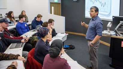 A lecturer standing in front of students teaching