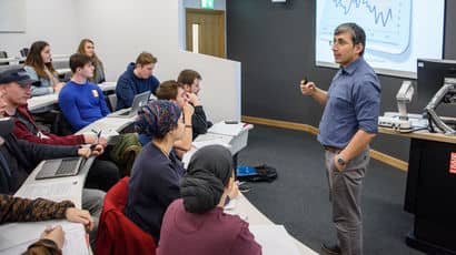 A lecturer standing in front of students teaching