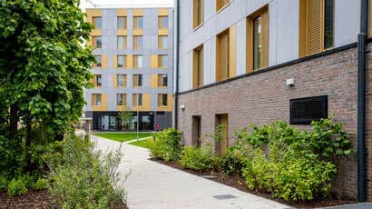 Looking down the path next to shrubs at a student accommodation block.