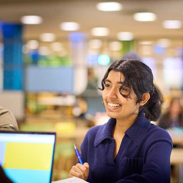 Girl smiling at a person over a counter.