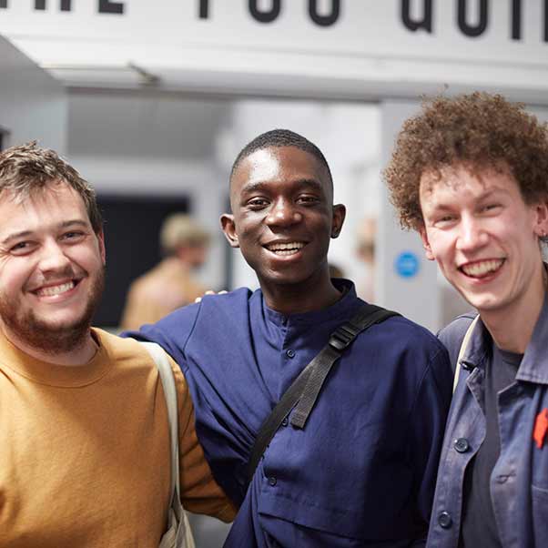 Three undergraduate students smiling at the camera