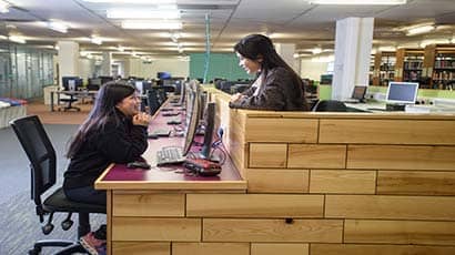 Two students talking over a computer