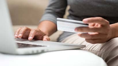 Close up of someone inputting credit/debit card details to a laptop