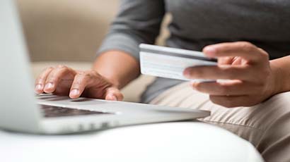 Close up of someone inputting credit/debit card details to a laptop