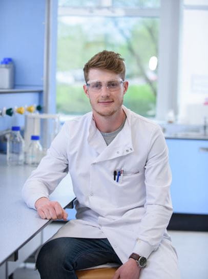 Student Willis smiling at the camera in a science lab