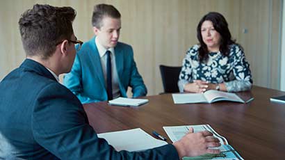 Two students on placement at the Hargreaves Lansdown in Bristol, having a meeting with a staff member