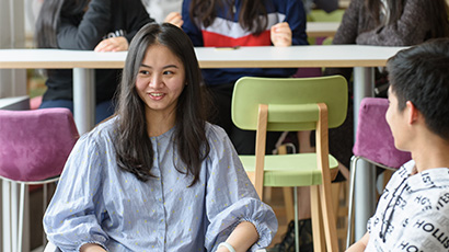 Two students sat at a coffee table talking