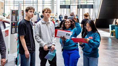 Student Ambassadors giving directions to two prospective students at an Open Day.