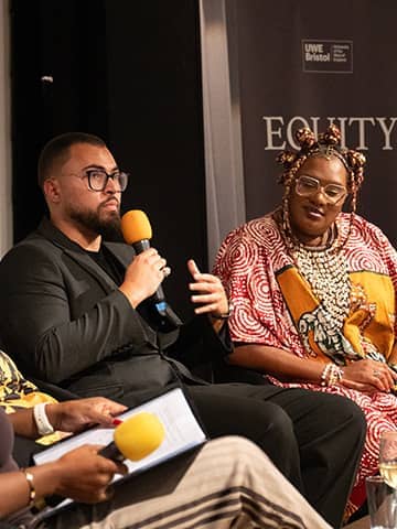 Speaker, Lewis Wedlock, talking on stage next to Mo Ebengho.