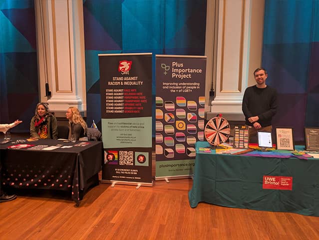 Information stalls at the event, including displays from 'Stand Against Racism and Inequality' and the 'Plus Importance Project'.