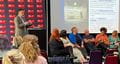 Presenter on stage at the A Tale of Two Cities BDAS event