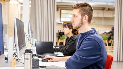 A student using a computer in a study space.