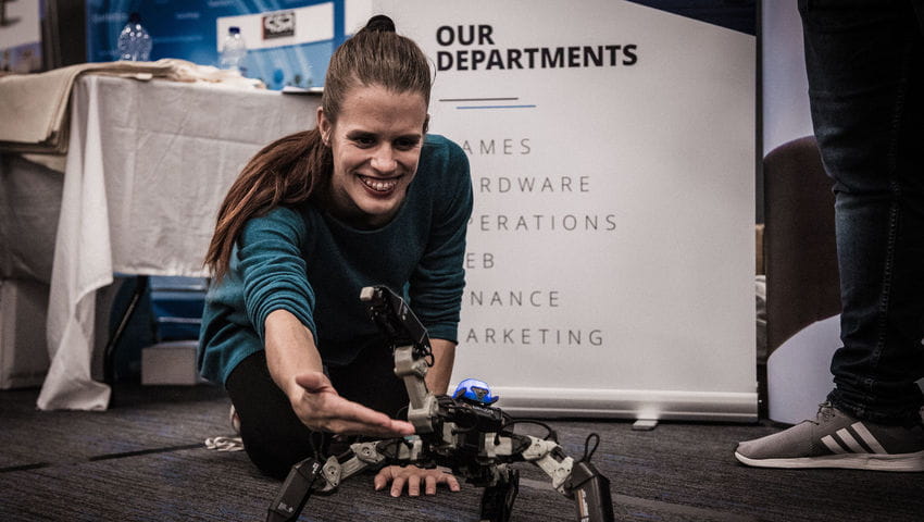 A woman touches a robot at the employers fair