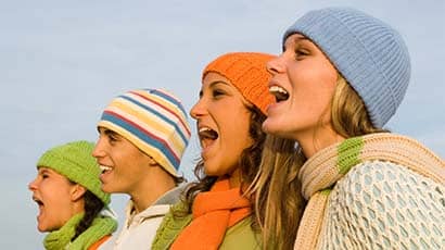 Group of people singing in profile.