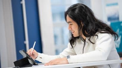 Student writing on a tablet in a study space at Glenside Library