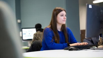 Student working at a desktop computer in a study space.