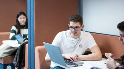 Students working together on a laptop in a study space